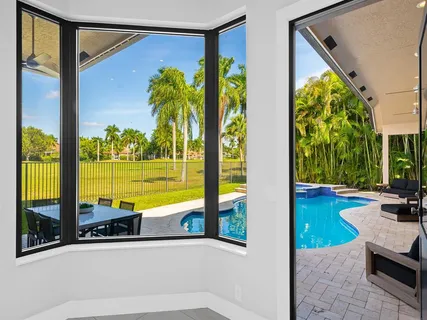 a view of swimming pool with a table and chairs under an umbrella