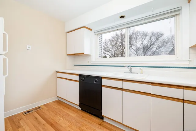 a kitchen with a sink cabinets and a large window