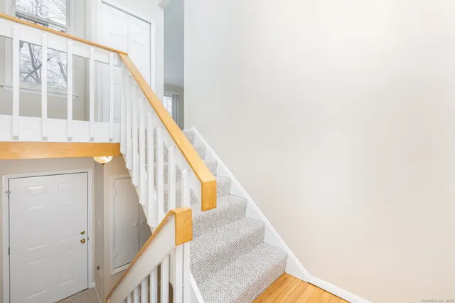 a view of staircase with railing and white walls