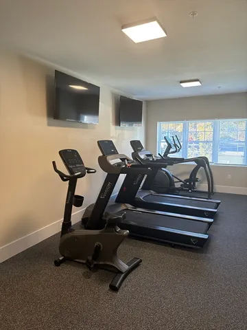 a room with gym equipment and a flat screen tv