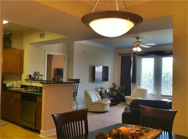 a living room with furniture a large window and a chandelier