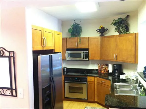 a kitchen with a refrigerator and a stove top oven