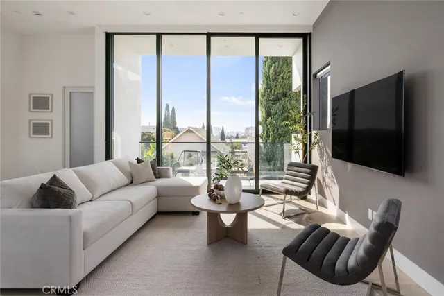 a living room with furniture a flat screen tv and a large window