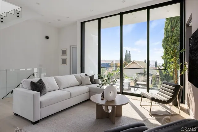 a living room with furniture kitchen view and a flat screen tv