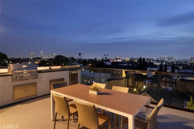 a view of a kitchen with kitchen island a sink a stove and wooden floor