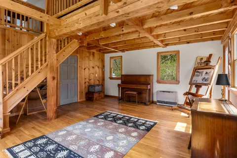 a living room with furniture a flat screen tv and a floor to ceiling window