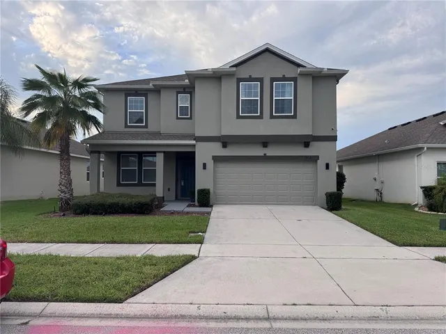 a front view of a house with a yard and garage