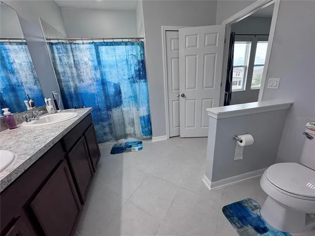 a bathroom with a sink a toilet and shower curtain