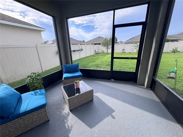 a living room with furniture and a floor to ceiling window