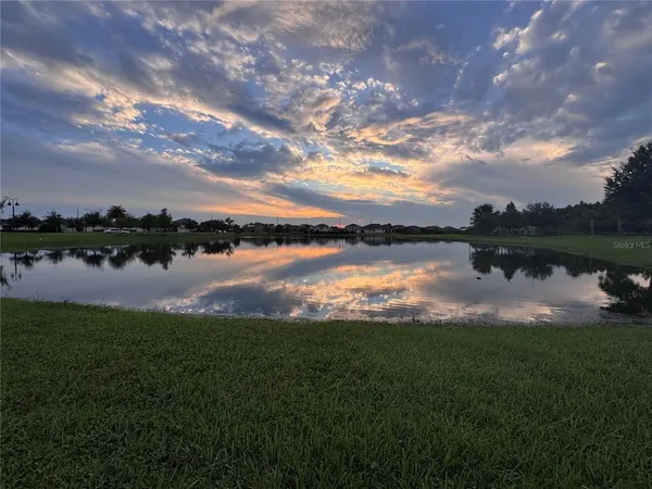 a view of a lake with houses in back