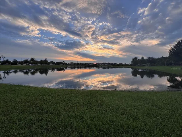 a view of a lake with houses in back