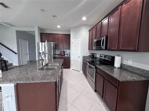 a kitchen with stainless steel appliances granite countertop a sink stove and refrigerator
