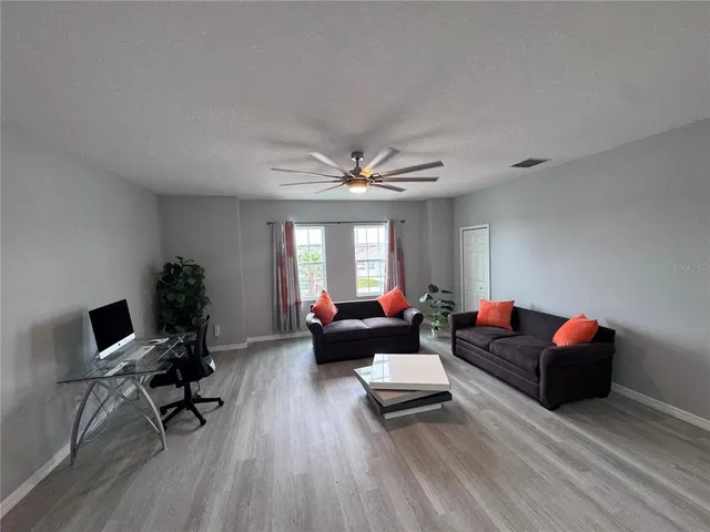a living room with furniture and a wooden floor