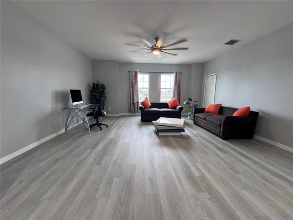 a living room with furniture and a wooden floor