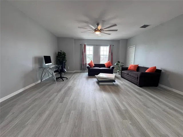 a living room with furniture and a wooden floor
