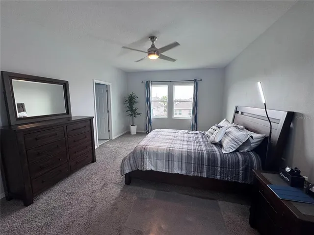a bedroom with a bed and a flat tv screen on dresser