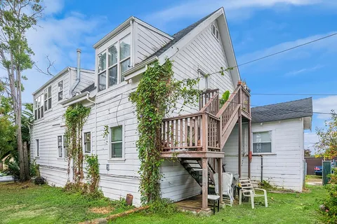 a view of a house with brick walls and a yard with plants