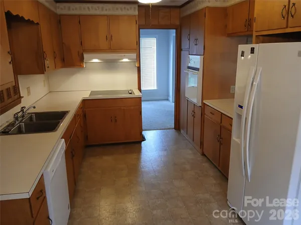 a kitchen with granite countertop a refrigerator and a sink