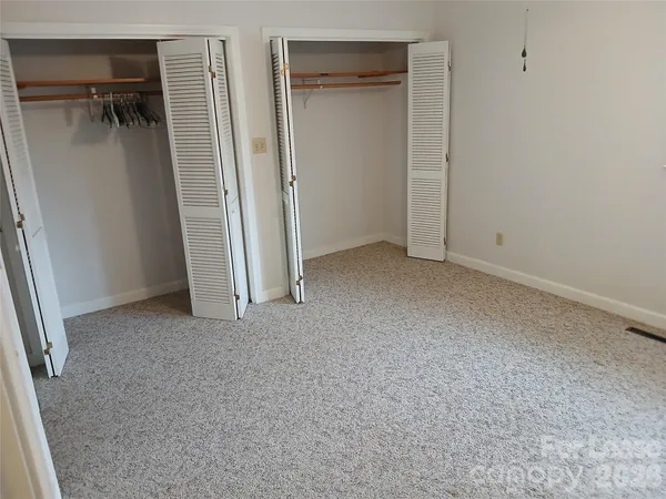 an empty room with closet and a window