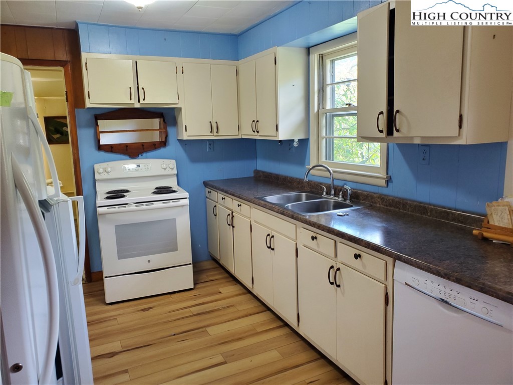 1411 Cabbage Creek Road Creston, NC 28615 - Photo 11 of 41 a kitchen with granite countertop a sink cabinets stainless steel appliances and a window
