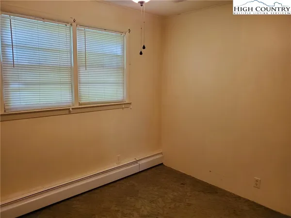 a view of a room with wooden floor and a window