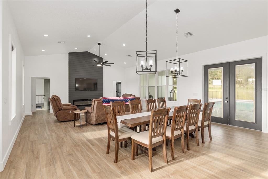 15224 Northwest 56th Court Road Reddick, FL 32686 - Photo 14 of 50 a view of a dining room and livingroom with furniture wooden floor a chandelier