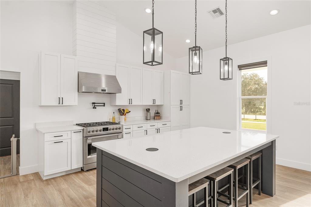 15224 Northwest 56th Court Road Reddick, FL 32686 - Photo 25 of 50 a white kitchen with a sink a stove and wooden floor