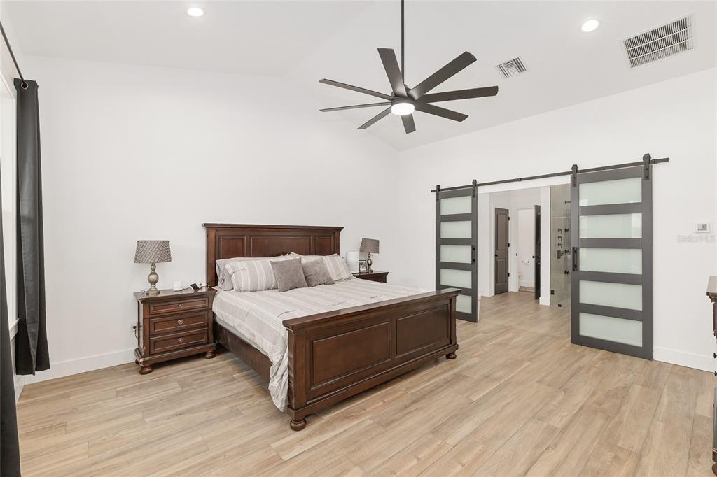 15224 Northwest 56th Court Road Reddick, FL 32686 - Photo 29 of 50 a bedroom with a bed and a chandelier