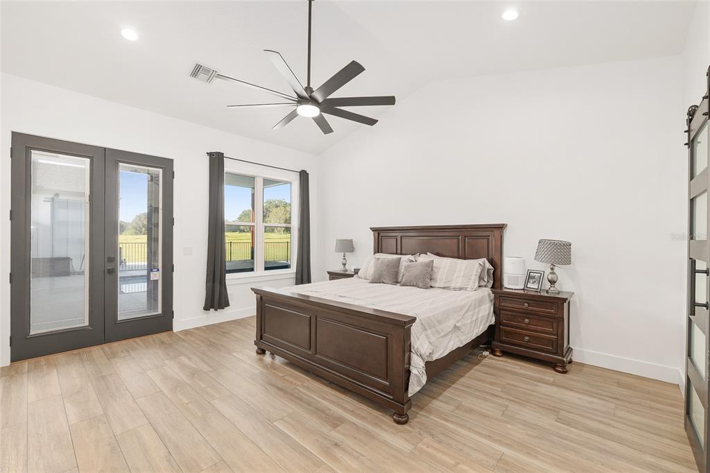 15224 Northwest 56th Court Road Reddick, FL 32686 - Photo 30 of 50 a bedroom with a large bed and a chandelier