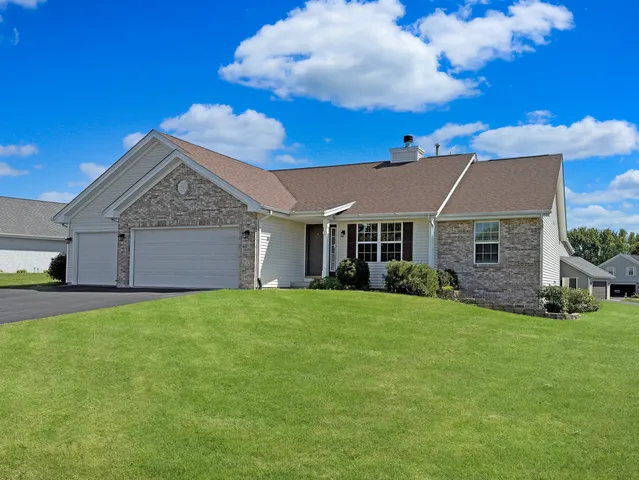 a view of a yard in front of a house with plants and large tree