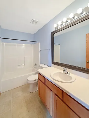 a bathroom with a granite countertop sink toilet a large mirror a bathtub and shower