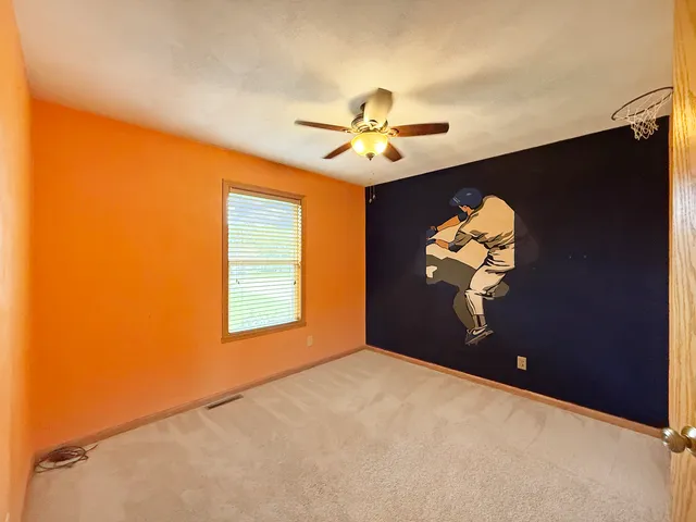 a view of a livingroom with a chandelier fan and a window