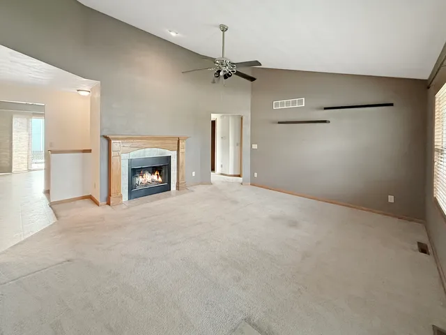 an empty room with windows and fireplace