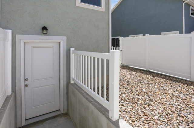 3636 West 910 South Syracuse, UT 84075 - Photo 59 of 70 Side entry with a white paneled door, exterior wall light, and concrete landing