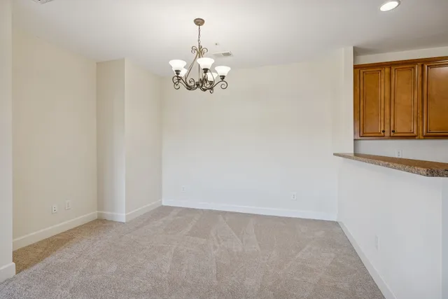 a view of a livingroom with a chandelier furniture and windows