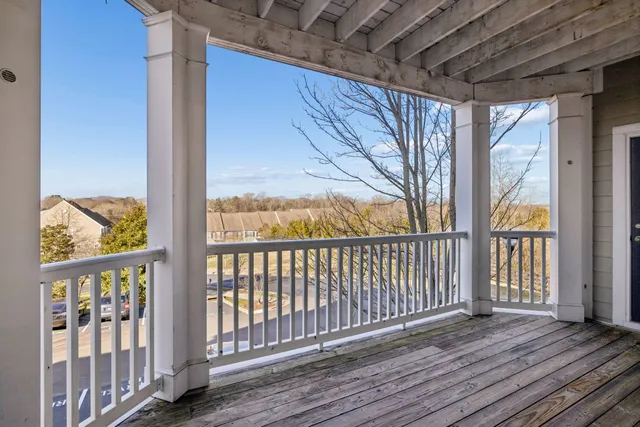 a view of a balcony with wooden floor and fence