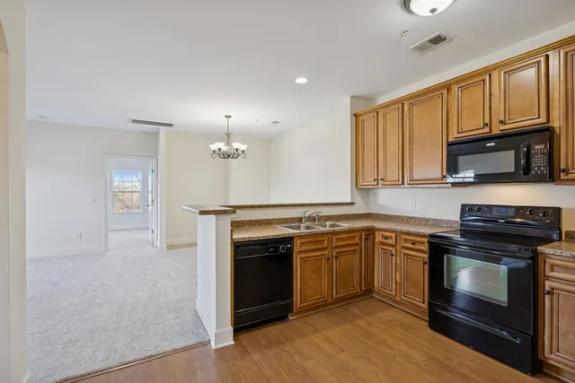 a kitchen with stainless steel appliances granite countertop a stove top oven a sink dishwasher and a microwave oven on the blue kitchen countertops