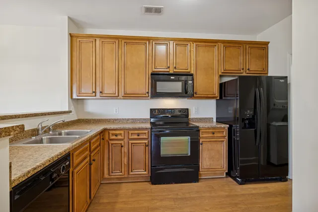 a kitchen with stainless steel appliances granite countertop a stove microwave refrigerator and sink