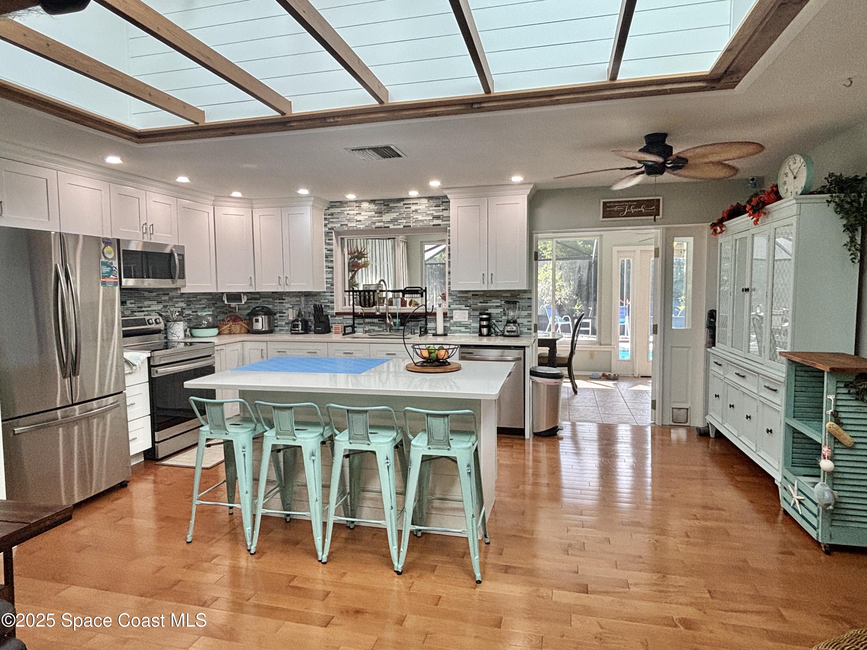 3955 Fooshe Avenue Sebastian, FL 32976 - Photo 8 of 45 a large kitchen with a table chairs refrigerator and cabinets