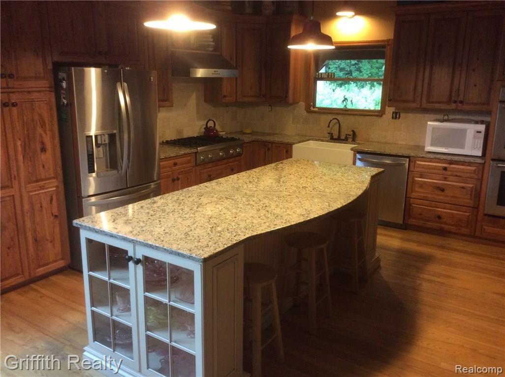 6591 Crofoot Road Fowlerville, MI 48836 - Photo 14 of 51 Fabulous kitchen: stainless appliances, gas stove top and double ovens. Granite counters, hardwood floors!
