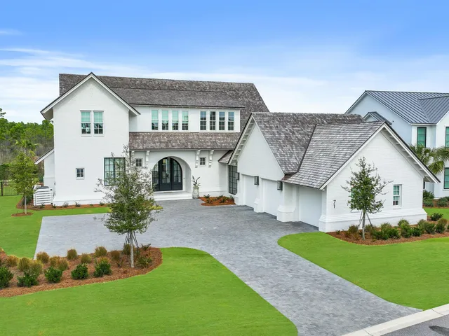 a front view of a house with a garden and plants