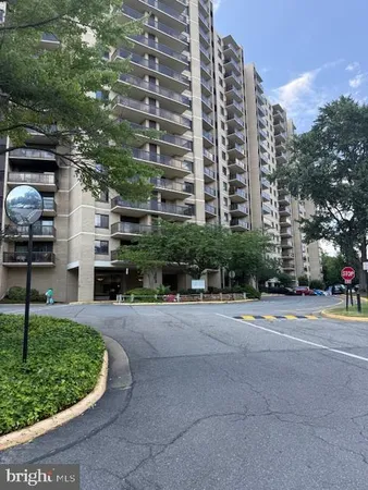 a view of a tall building with a yard and plants