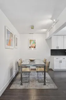 a living room with stainless steel appliances furniture a dining table and kitchen view