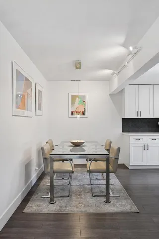 a living room with stainless steel appliances furniture a dining table and kitchen view