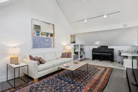a living room with furniture and a piano