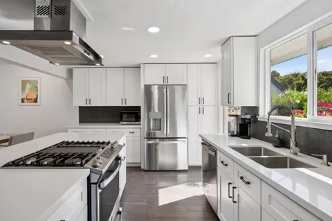 a kitchen with white cabinets and stainless steel appliances