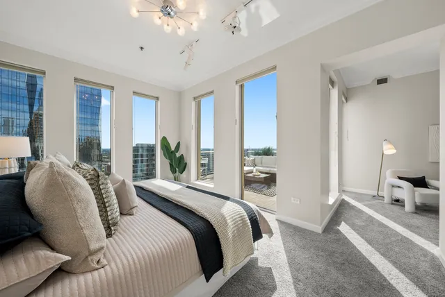 a bedroom with a large bed and a chandelier
