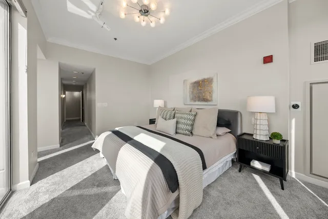 a bedroom with bed and a chandelier