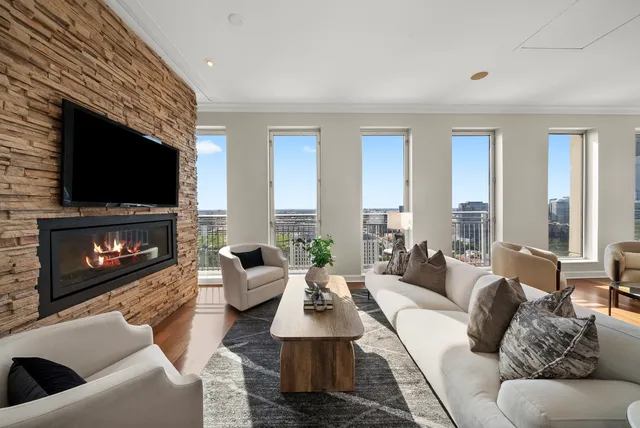 a living room with furniture a flat screen tv and a fireplace