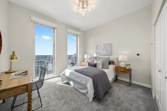 a bedroom with a large bed and a chandelier